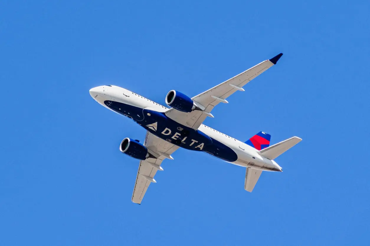 Delta Airlines aircraft in flight An airplane flying directly above with "DELTA" written on the bottom of the plane. August 1, 2019 Santa Clara / CA / USA - Delta Airlines aircraft in flight; the Delta Logo visible on the airplanes' underbelly; blue sky background